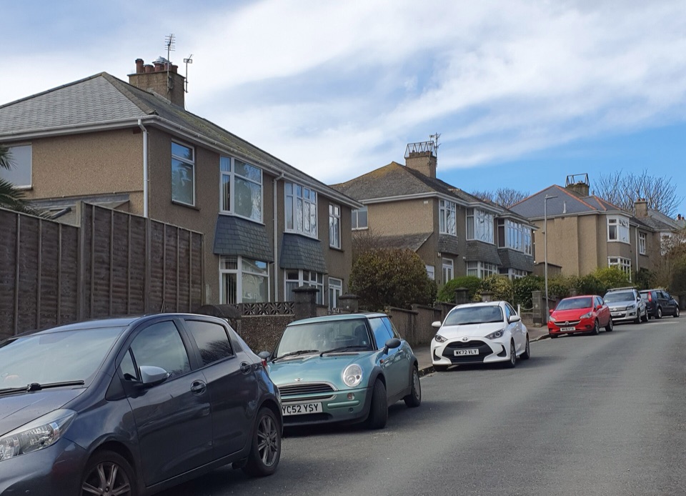 A row of rendered semi detached houses along a residential street in England
